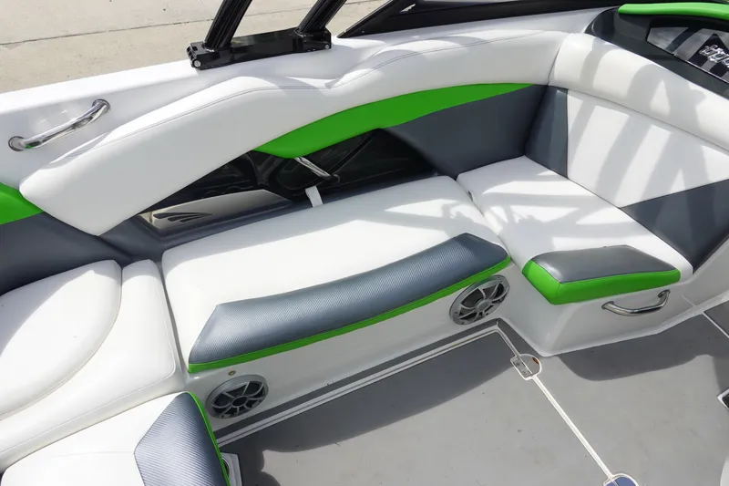 Slide: The Image of 2015 Tigé R20 boat interior with white and green seating, featuring built-in speakers. - 13