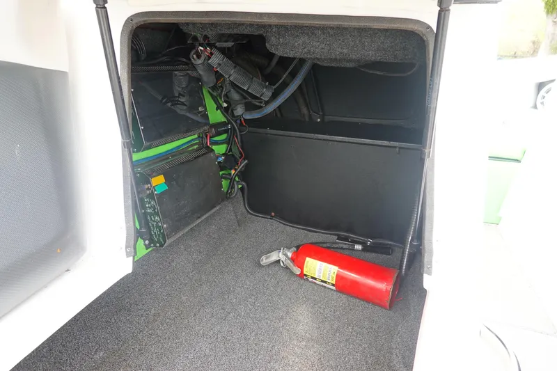 Slide: The Image of 2015 Tigé R20 boat storage compartment with fire extinguisher and wiring. - 15