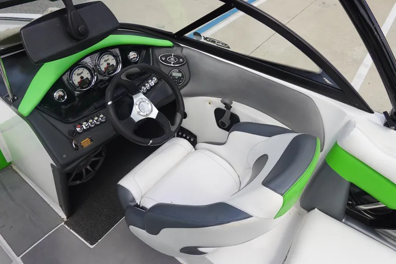 Slide: The Image of 2015 Tigé R20 boat cockpit with green accents, steering wheel, and gauges. - 16