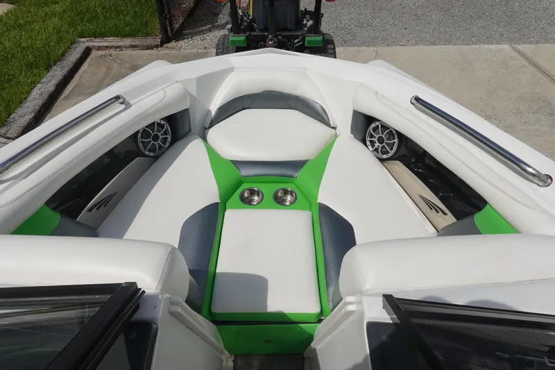 Slide: The Image of 2015 Tigé R20 boat interior with green and white seating, cup holders, and speakers. - 18