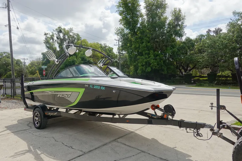 Slide: The Image of 2015 Tigé R20 boat on trailer, black and green design, parked outdoors. - 3