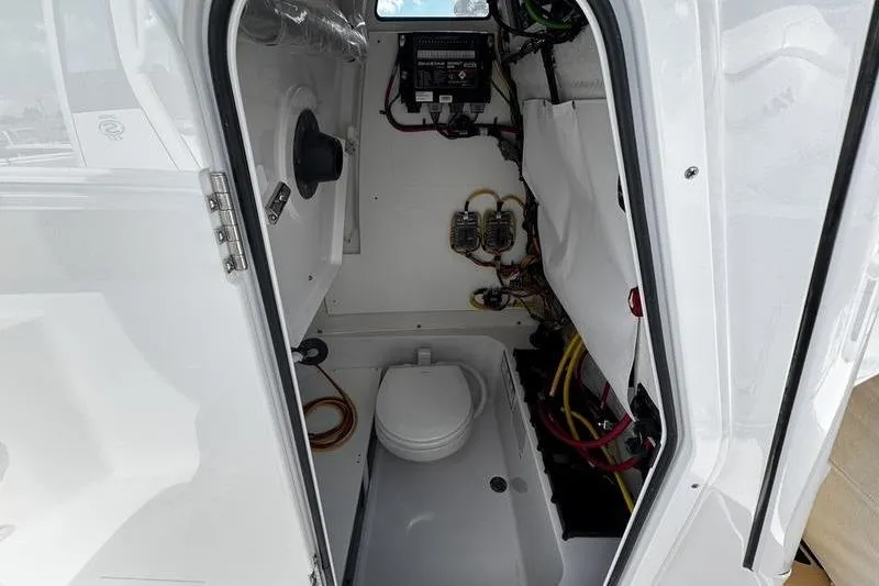 Slide: The Image of Interior of 2026 Sportsman Heritage 231 Center Console boat, featuring compact marine toilet. - 12