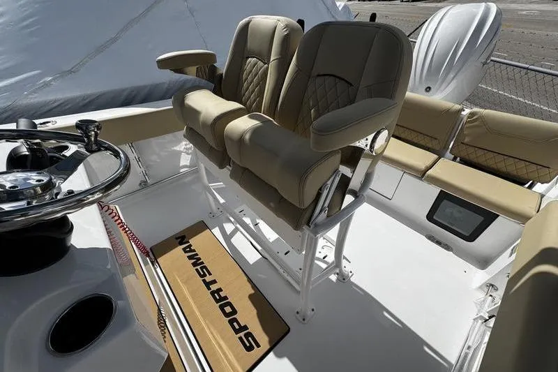 Slide: The Image of 2026 Sportsman Heritage 231 Center Console boat interior with beige seating and steering wheel. - 15