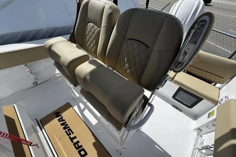 Slide: The Image of 2026 Sportsman Heritage 231 Center Console boat interior with tan cushioned seating. - 16
