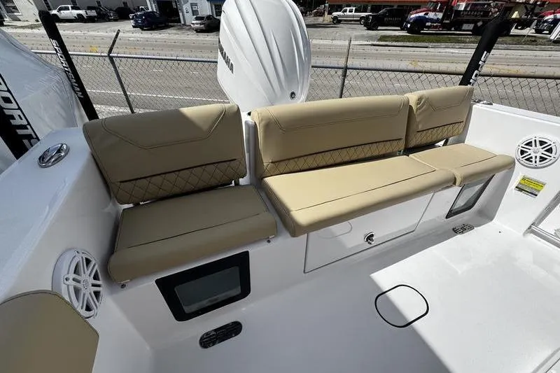 Slide: The Image of 2026 Sportsman Heritage 231 Center Console boat interior with beige seating and storage compartments. - 26