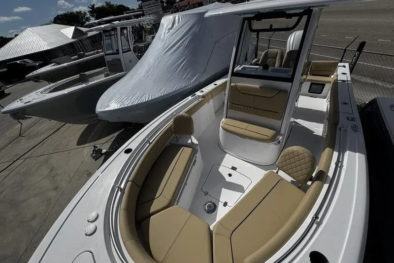 Slide: The Image of 2026 Sportsman Heritage 231 Center Console boat with tan seating, docked outdoors. - 7