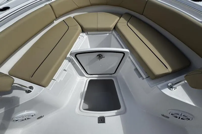 Slide: The Image of 2026 Sportsman Heritage 231 Center Console boat interior with tan cushioned seating and storage compartment. - 8