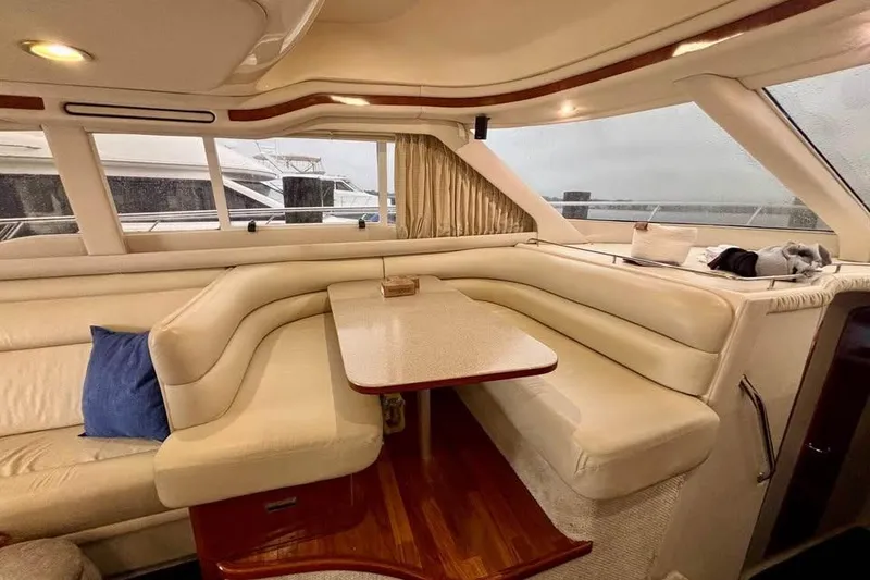 Slide: The Image of Luxurious interior of a 2003 Sea Ray 480 Sedan Bridge yacht with plush seating and table. - 12