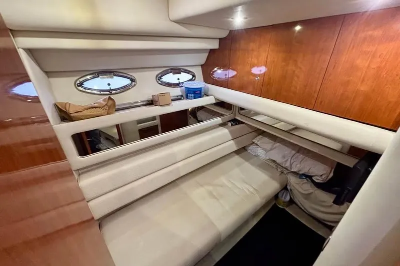 Slide: The Image of Interior cabin of 2003 Sea Ray 480 Sedan Bridge yacht, featuring cozy seating and wooden accents. - 16