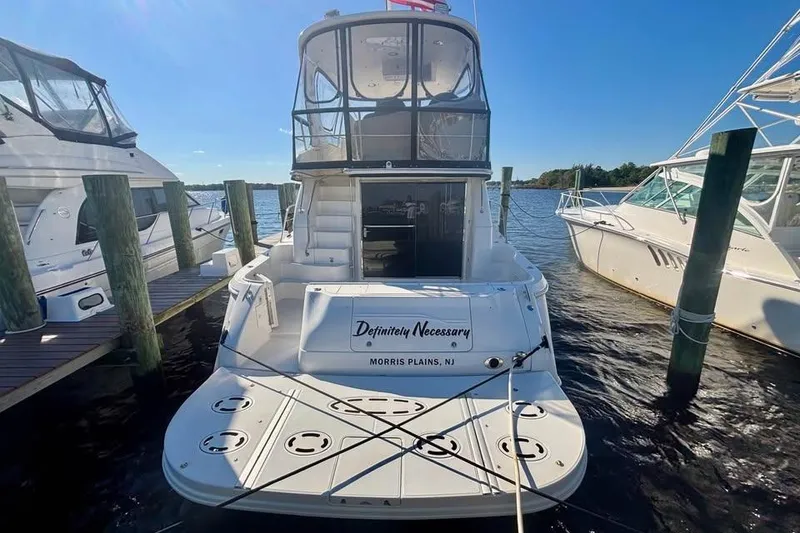 Slide: The Image of 2003 Sea Ray 480 Sedan Bridge yacht docked at marina, rear view. - 2
