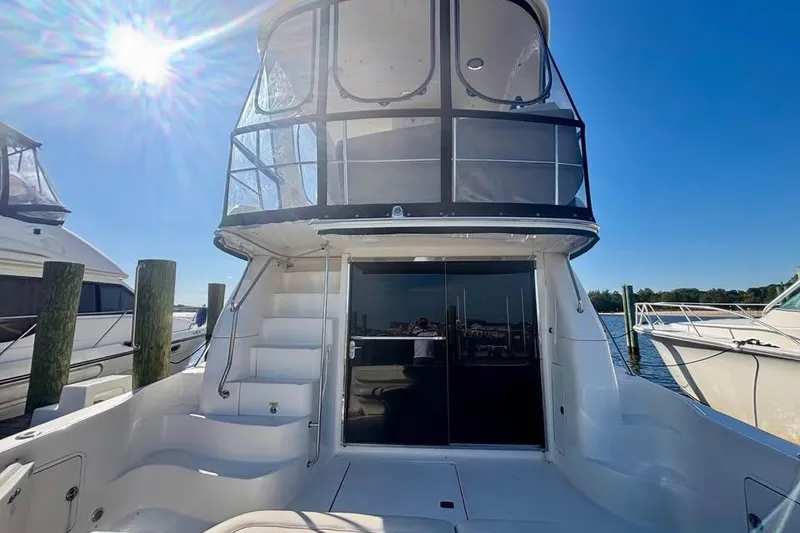 Slide: The Image of 2003 Sea Ray 480 Sedan Bridge yacht docked under clear blue sky. - 3