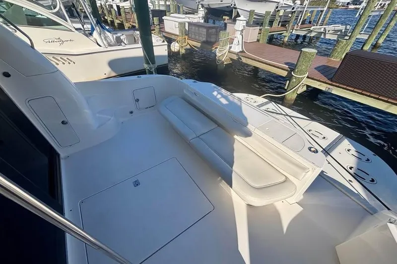 Slide: The Image of 2003 Sea Ray 480 Sedan Bridge yacht deck with seating, docked at marina. - 4