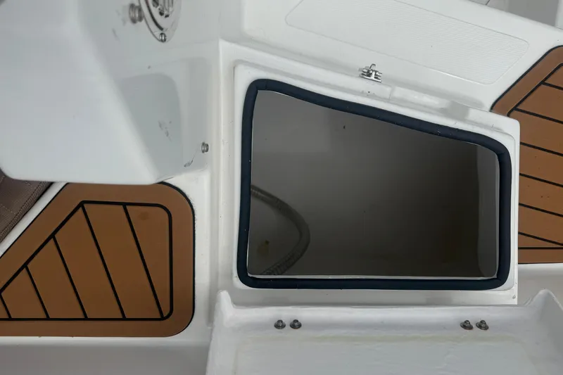 Slide: The Image of Open storage compartment on 2025 Drive Wave 570 boat with wood accents. - 12