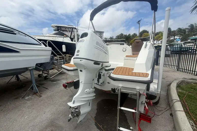 Slide: The Image of 2025 Drive Wave 570 boat with Suzuki outboard motor, docked at marina. - 4