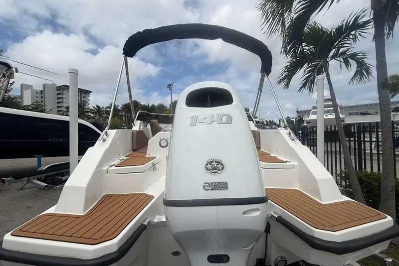 Slide: The Image of 2025 Drive Wave 570 boat with sleek design, docked under palm trees. - 5