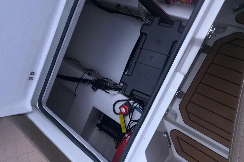 Slide: The Image of Open storage compartment in 2025 Drive Wave 570 boat, showing battery and wiring. - 14