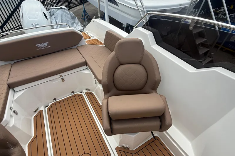 Slide: The Image of Luxurious seating on 2025 Drive Wave 570 boat with brown upholstery and teak flooring. - 15