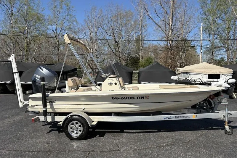 Slide: The Image of 2016 Scout 177 Sport boat on trailer, parked outdoors with trees in background. - 10