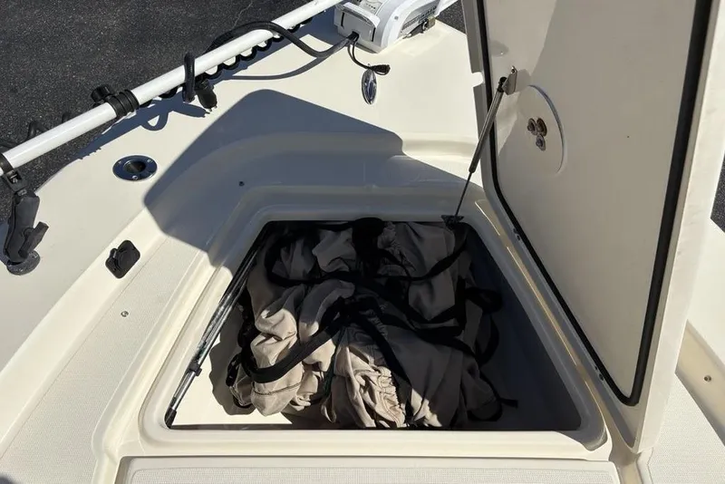Slide: The Image of Open storage compartment on a 2016 Scout 177 Sport boat, containing fabric items. - 12