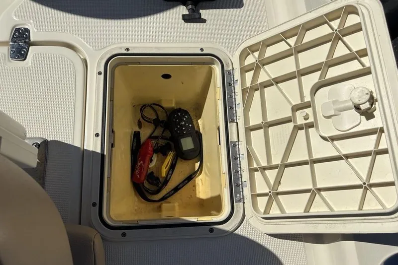 Slide: The Image of Open storage compartment on 2016 Scout 177 Sport boat with tools and equipment inside. - 18