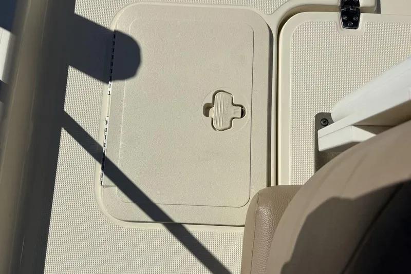 Slide: The Image of 2016 Scout 177 Sport boat deck with storage hatch and beige seating. - 21