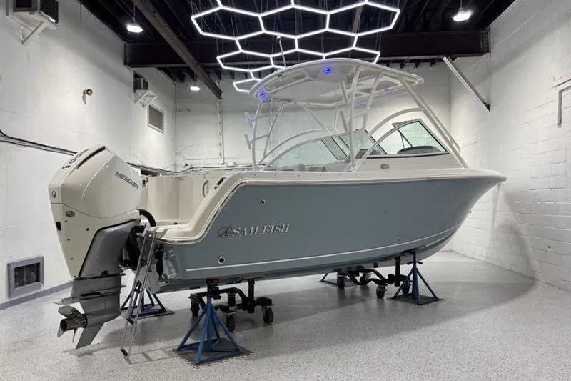 The Image of 2025 Sailfish 245 DC boat displayed indoors on stands. - 0