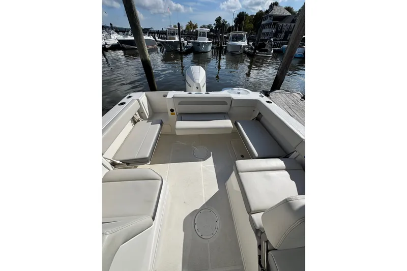 Slide: The Image of 2025 Sailfish 245 DC boat interior with spacious seating at a marina. - 6