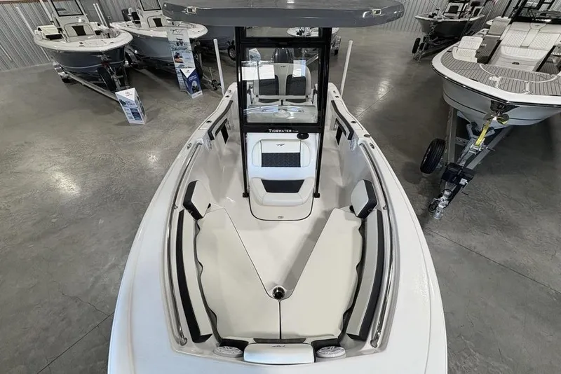 Slide: The Image of 2026 Tidewater 210 CC Adventure boat interior, showcasing seating and console in showroom. - 25