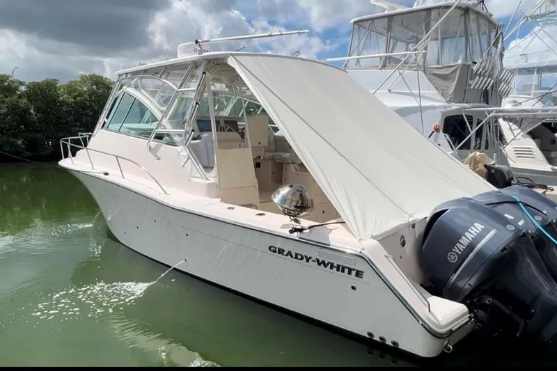 The Image of 2011 Grady-White Express 360 boat docked with Yamaha engines, under a cloudy sky. - 0