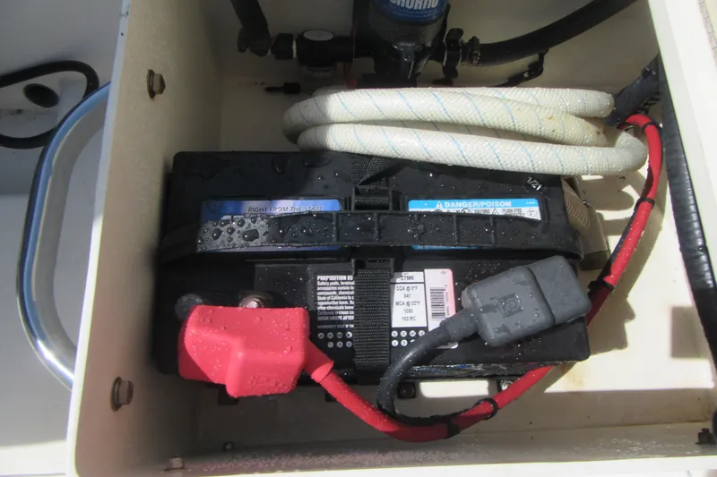 Slide: The Image of Battery compartment of a 2006 Parker 2120 Sport Cabin boat with cables and hose. - 13