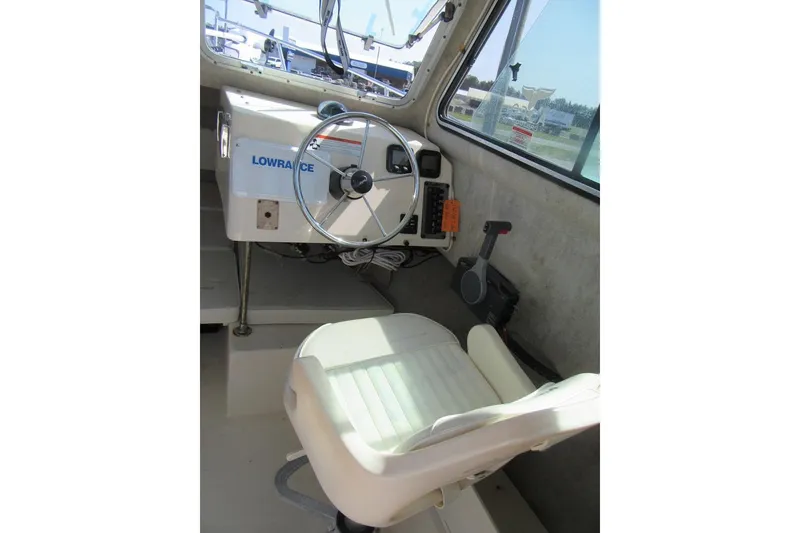 Slide: The Image of Interior of 2006 Parker 2120 Sport Cabin boat with steering wheel and control panel. - 24
