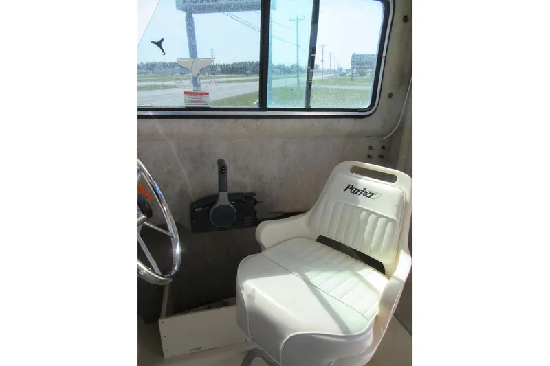 Slide: The Image of Interior of a 2006 Parker 2120 Sport Cabin boat with steering wheel and branded seat. - 25