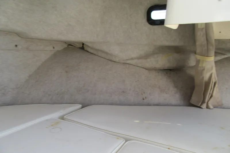 Slide: The Image of Interior cabin view of a 2006 Parker 2120 Sport Cabin boat, featuring seating and a window. - 33