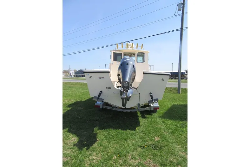 Slide: The Image of 2006 Parker 2120 Sport Cabin boat on trailer, displayed outdoors on grass. - 4