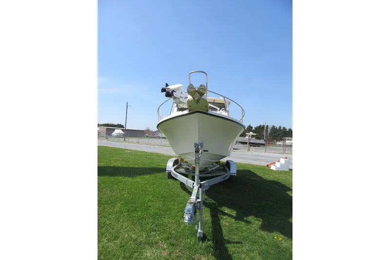 Slide: The Image of 2006 Parker 2120 Sport Cabin boat on trailer, parked on grass under clear blue sky. - 6
