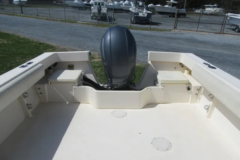 Slide: The Image of 2006 Parker 2120 Sport Cabin boat with outboard motor, docked on gravel. - 9