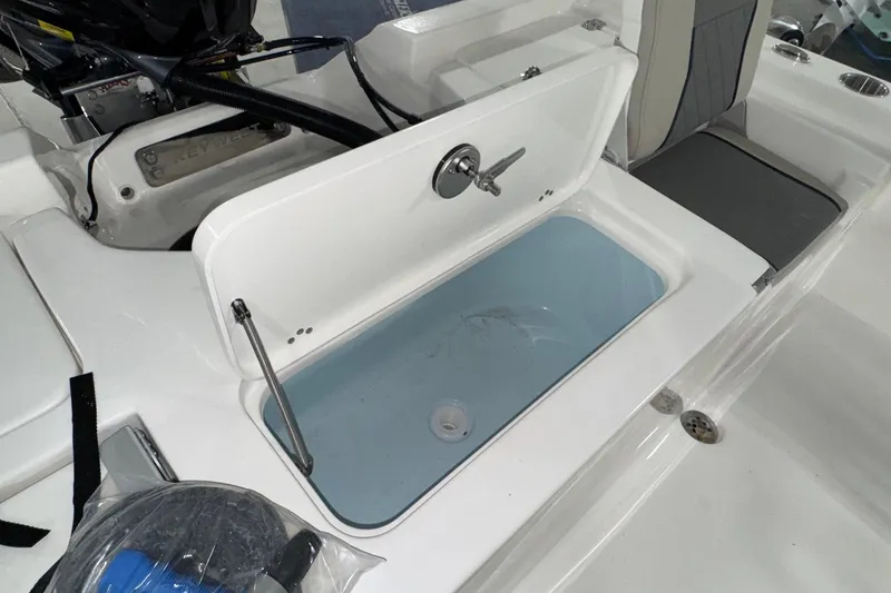 Slide: The Image of 2026 Key West 230 Bay Reef boat with open storage compartment and seating area. - 15