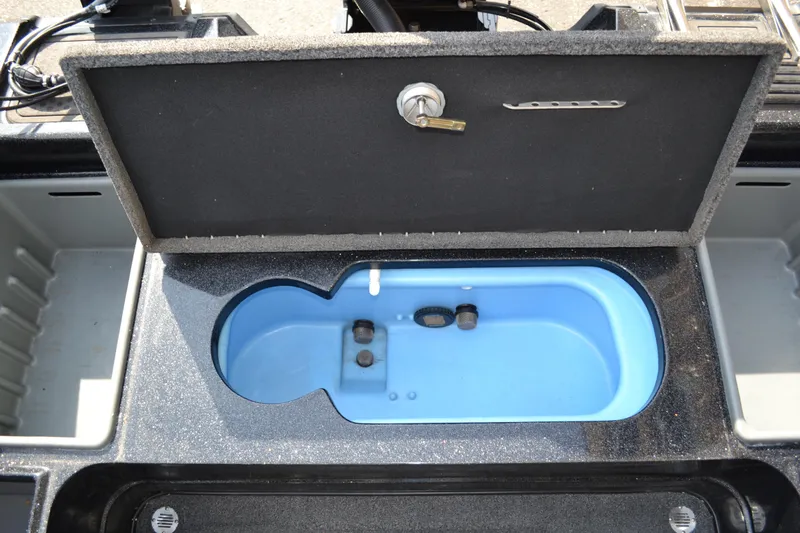 Slide: The Image of Open storage compartment in a 2022 Nitro ZV20 boat, featuring a blue interior. - 14