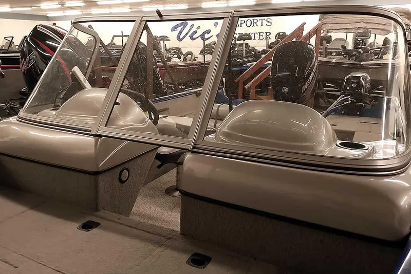 Slide: The Image of 2013 Tracker Pro Guide V-16 WT boat interior with windshield and seating in showroom. - 10