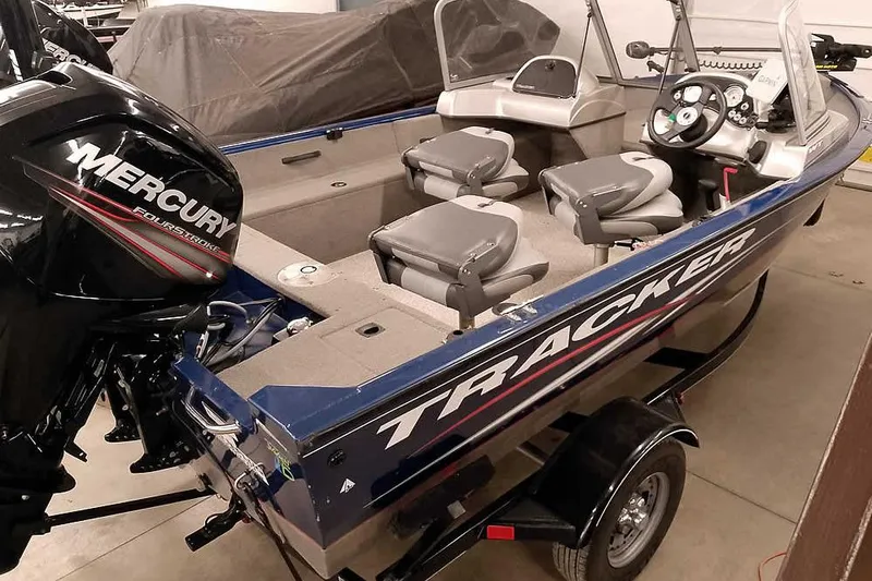 Slide: The Image of 2013 Tracker Pro Guide V-16 WT boat with Mercury engine in a garage. - 11