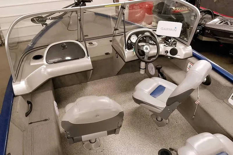 Slide: The Image of 2013 Tracker Pro Guide V-16 WT boat interior with steering wheel and seating. - 13