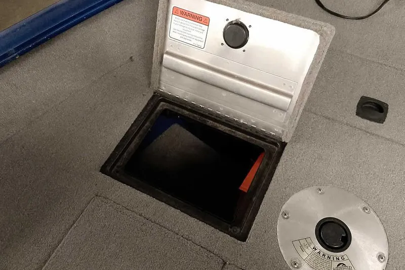 Slide: The Image of 2013 Tracker Pro Guide V-16 WT boat storage compartment with warning label. - 18