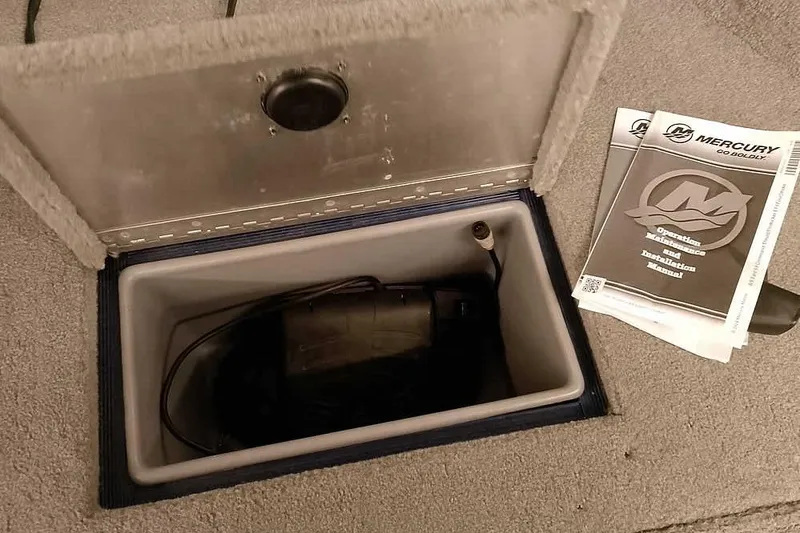 Slide: The Image of 2013 Tracker Pro Guide V-16 WT storage compartment with Mercury manuals and equipment. - 20