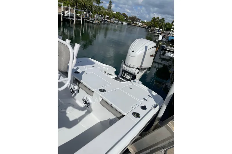 Slide: The Image of 2024 Sea Hunt BX 22 BR boat with Yamaha engine docked by calm waters. - 5