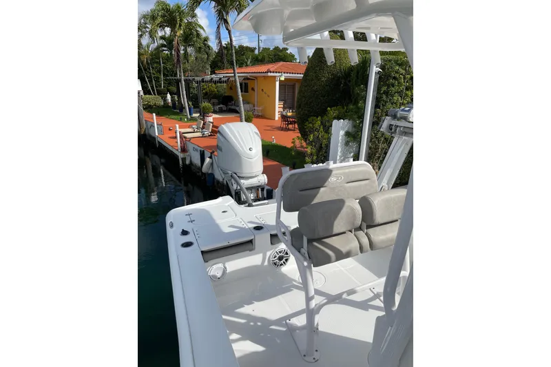 Slide: The Image of 2024 Sea Hunt BX 22 BR boat docked near a tropical waterfront home. - 6