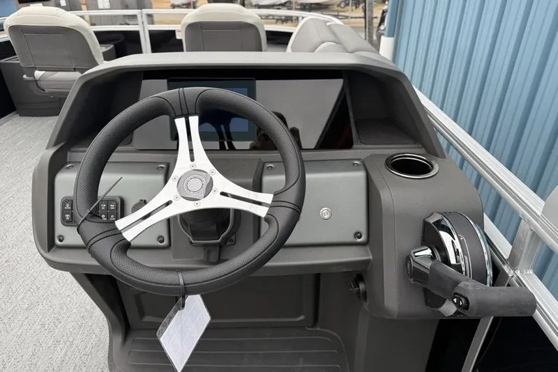 Slide: The Image of 2026 Sun Tracker Fishin' Barge 20 DLX steering console with modern controls and cup holder. - 18