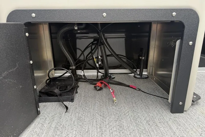 Slide: The Image of Open compartment with wiring inside a 2026 Sun Tracker Fishin' Barge 20 DLX boat. - 25
