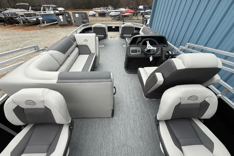 Slide: The Image of 2026 Sun Tracker Fishin' Barge 20 DLX interior with gray seating and steering console. - 27