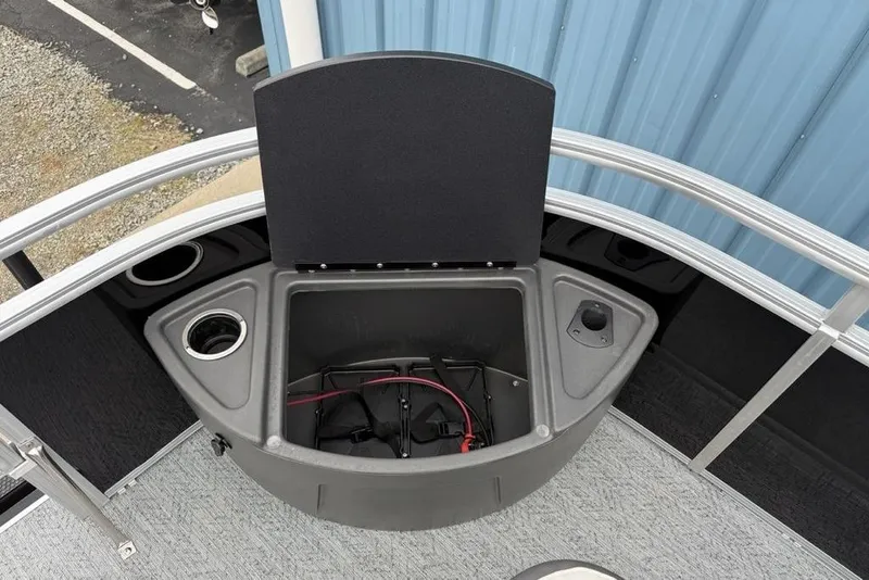 Slide: The Image of 2026 Sun Tracker Fishin' Barge 20 DLX boat storage compartment with cup holders. - 9