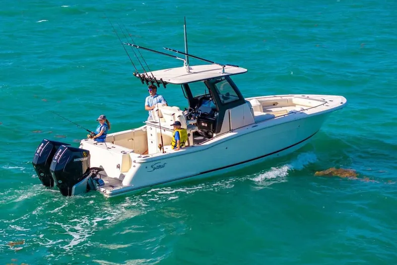 Slide: The Image of Manufacturer Provided Image: 2026 Scout 288 LXF boat cruising on clear blue water with passengers fishing. - 1